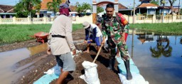 Babinsa bersama masyarakat melaksanakan pengurukan halaman sekolah