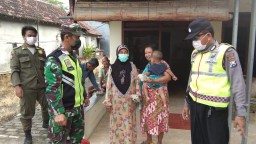 Babinsa Serka Nur Kasan bersama Babinkamtibmas bagikan nasi bungkus