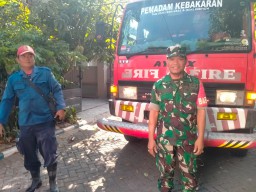 Babinsa 0816/01 Sarirogo gotong royong dengan warga padamkan kebakaran gudang cat kaleng.