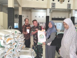 Babinsa Koramil 0816/01 Sidoarjo bantu penyaluran beras Bansos di kelurahan Pucanganom Sidoarjo.
