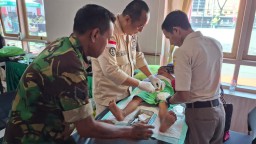 Serka M. Amri Babinsa Koramil 0816/01 Sidoarjo bantu warganya sunatan Masal HUT TNI Ke-80.