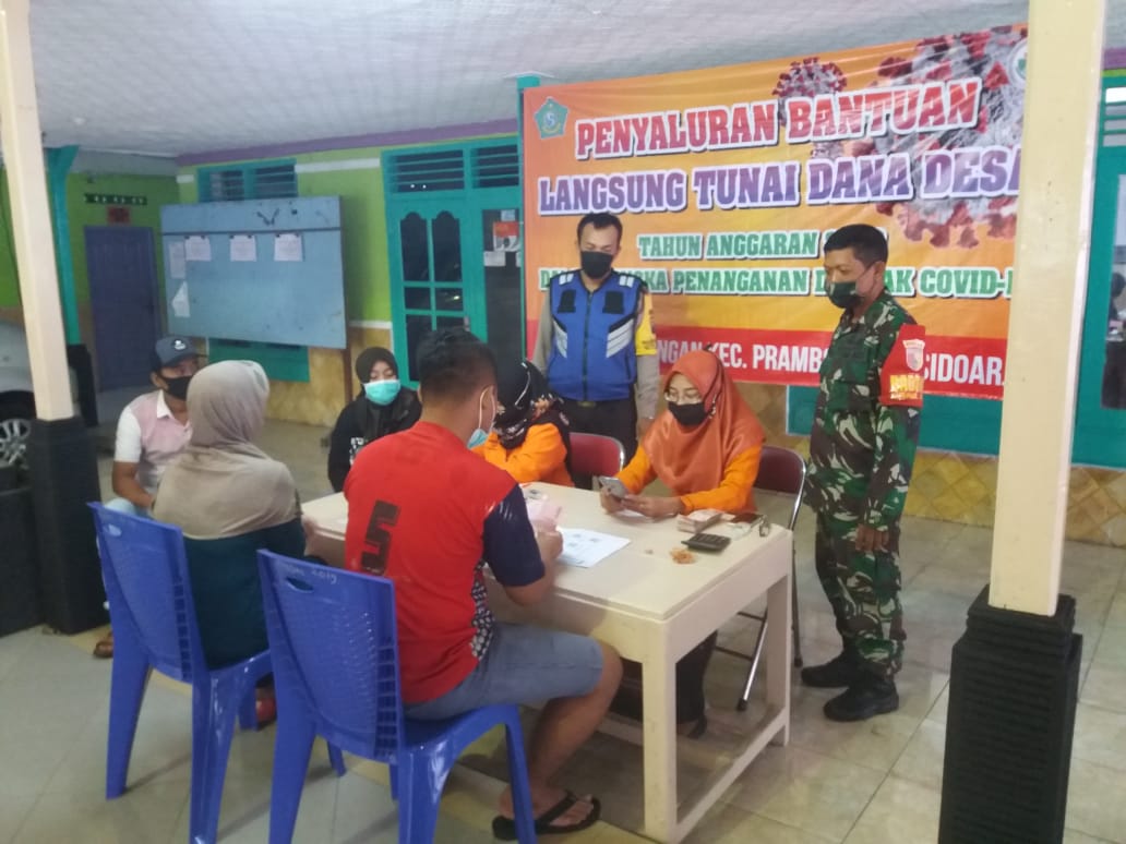 Babinsa Prambon bersama Babinkamtibmas dampingi Pemdes salurkan BST